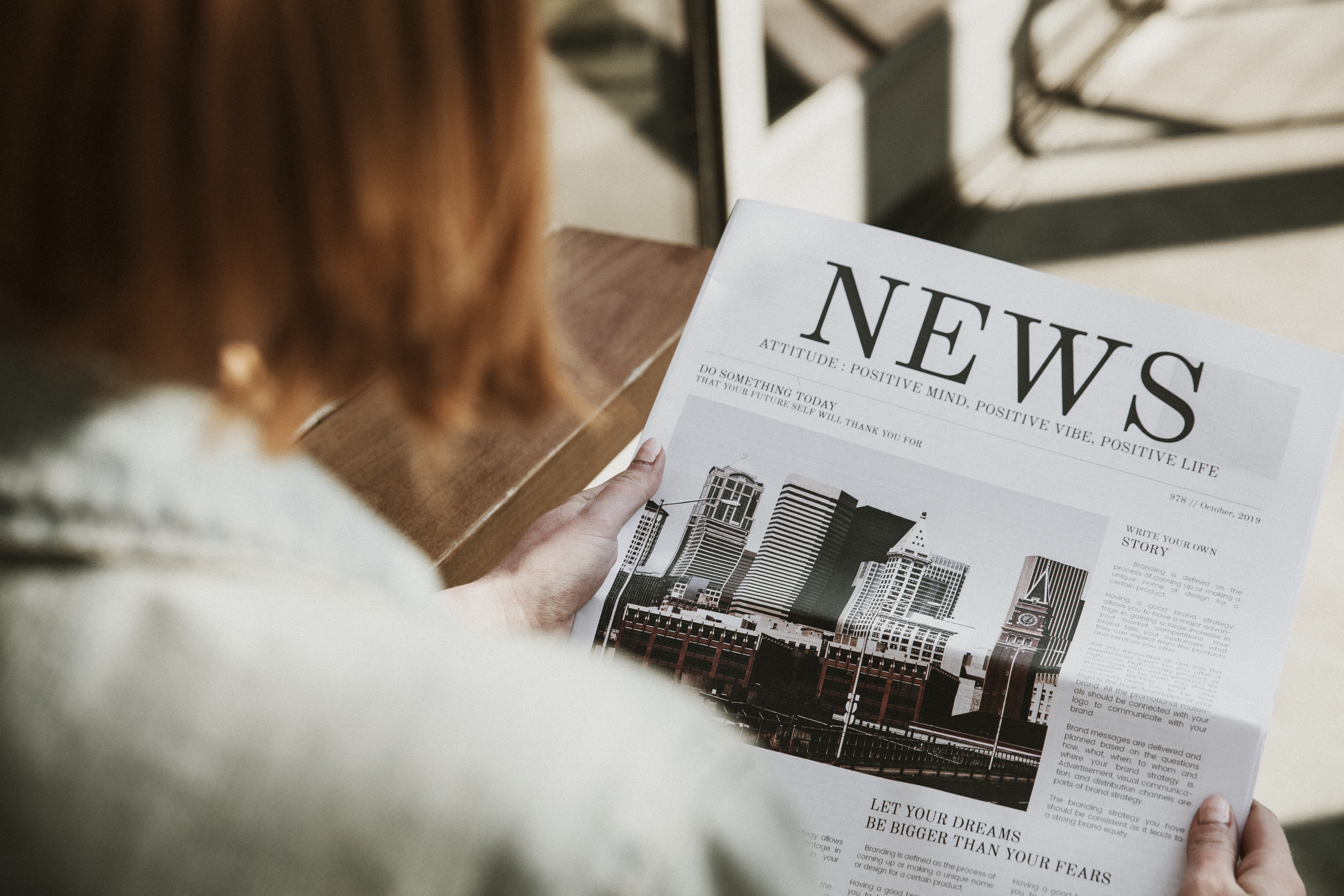 Woman reading a newspaper in a cafe